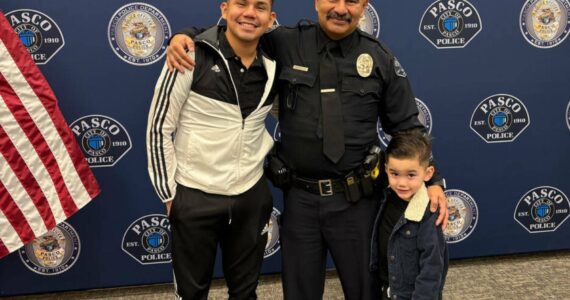 Victor Manuel Arzate poses with his son and retired officer Raymond Aparicio, who mentored Arzate growing up. (Mary Murphy for Cascade PBS)