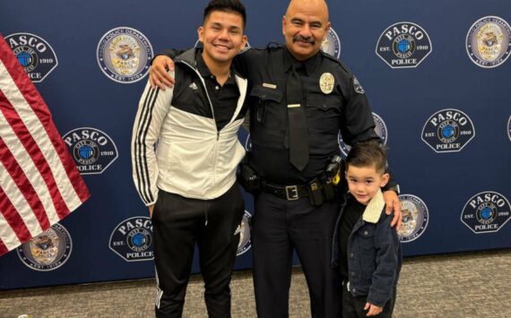 Victor Manuel Arzate poses with his son and retired officer Raymond Aparicio, who mentored Arzate growing up. (Mary Murphy for Cascade PBS)