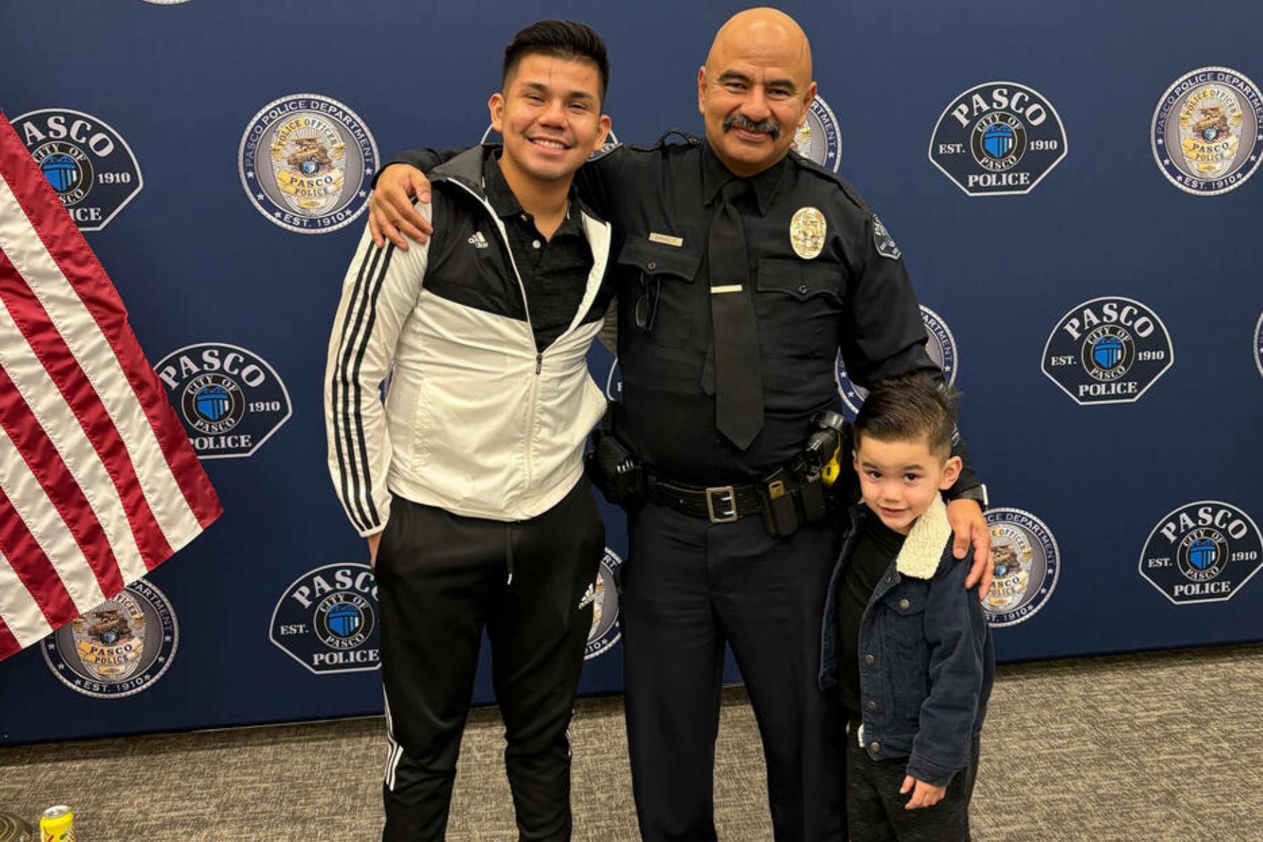 Victor Manuel Arzate poses with his son and retired officer Raymond Aparicio, who mentored Arzate growing up. (Mary Murphy for Cascade PBS)